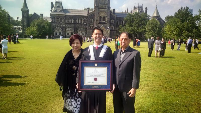 Joel Tan (middle) holding his U of T degree pictured with his parents on the U of T St. George campus