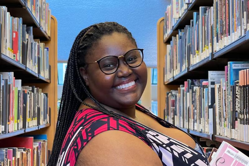 Lellow Sedio, a book and media studies graduate, pictured in a library.