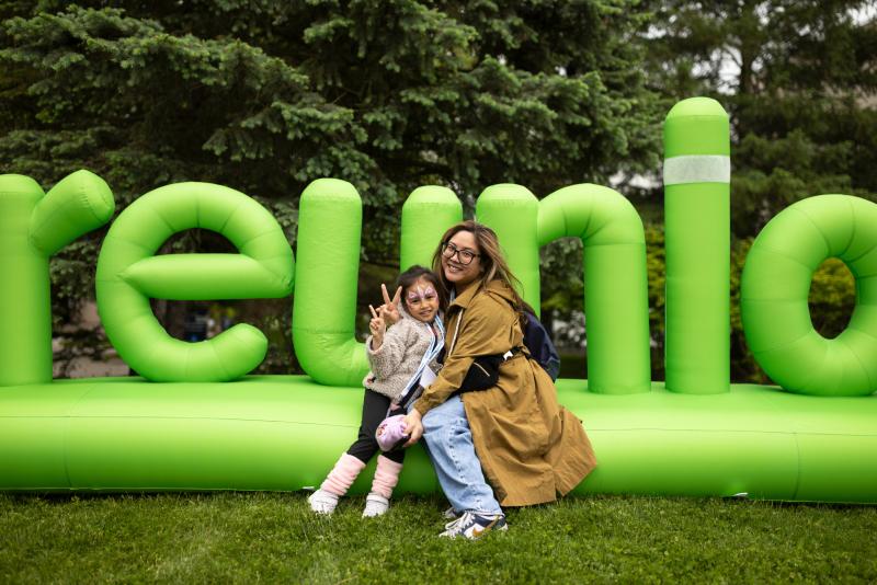 Alumni and their children pose in front of a Reunion inflatable.
