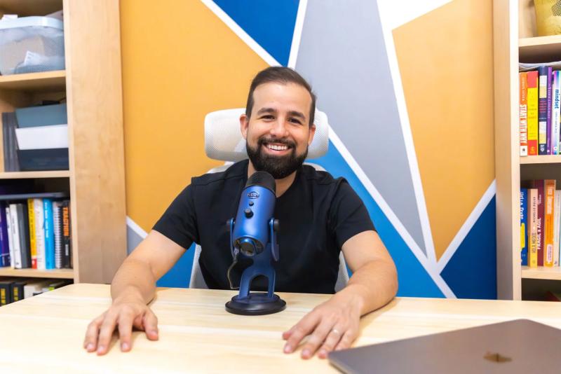 Stephan Dyer at a desk with a podcast microphone.