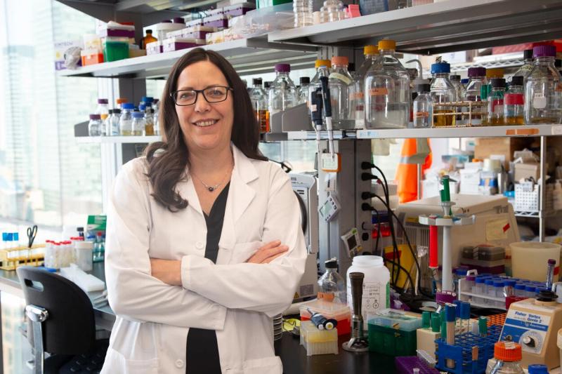 Karen Maxwell beside a laboratory bench in a biochemistry lab.